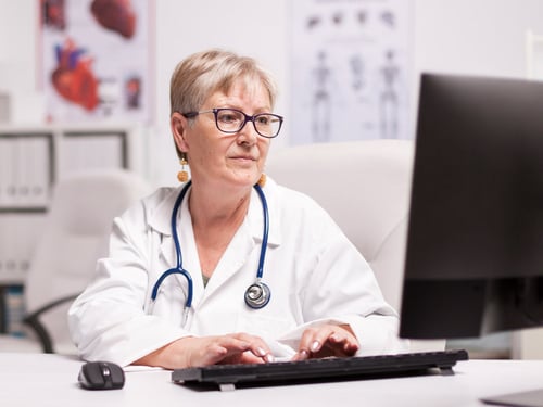 Middle aged female doctor using computer