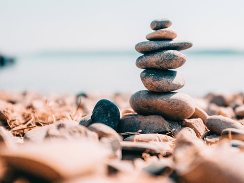 Stacked stones against blurred lake background