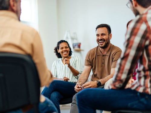 Group therapy session with two patients laughing
