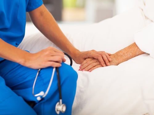 Nurse holding patients hand