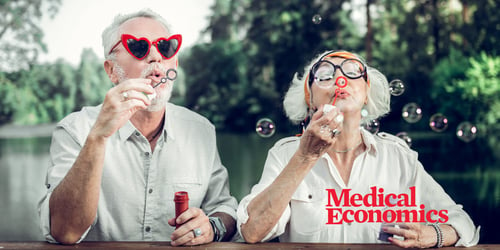 An elderly couple enjoying the outdoors while blowing bubbles and wearing funny sunglasses
