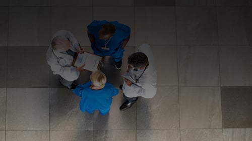 Overhead view of a team of doctors and nurses communicating in an open space